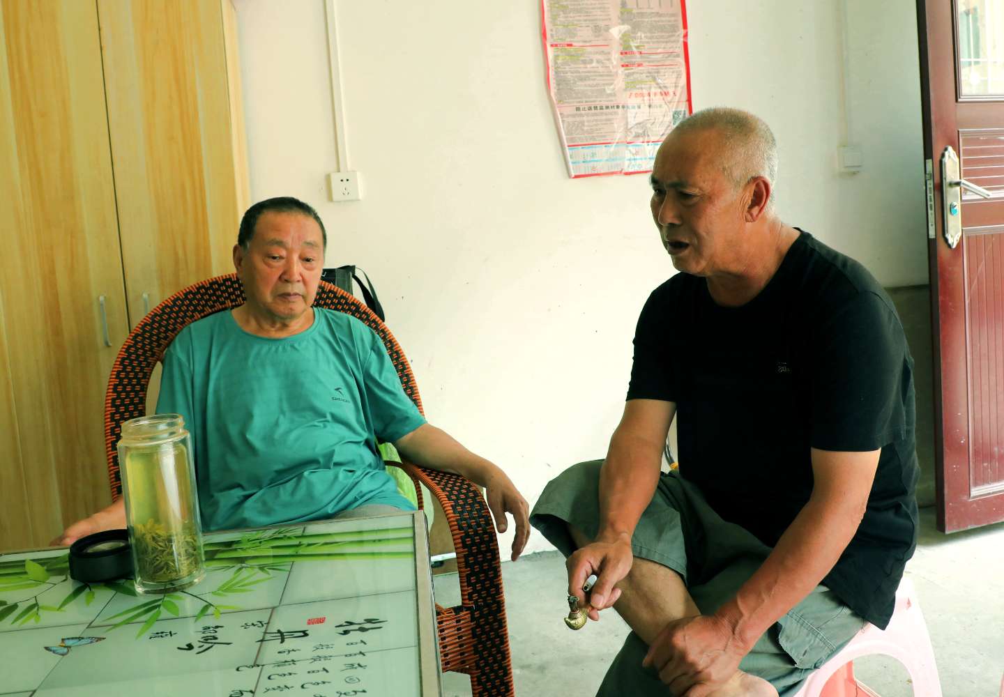 “土家歌王”唐腾华仔细品味熊正禄演唱《土家盘歌》。（汪登平摄） (2).JPG
